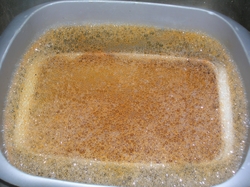 A photograph of the soapy water with curry soiled dish soaking within