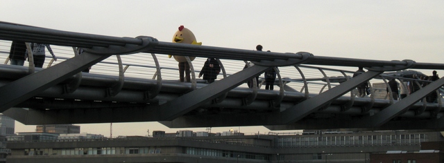 Photograph of someone dressed as a chicken, stood on London's Millennium Bridge