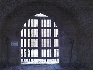 Bolton Castle: Photograph showing the view through the entrance passageway to the courtyard, barred by a portcullis